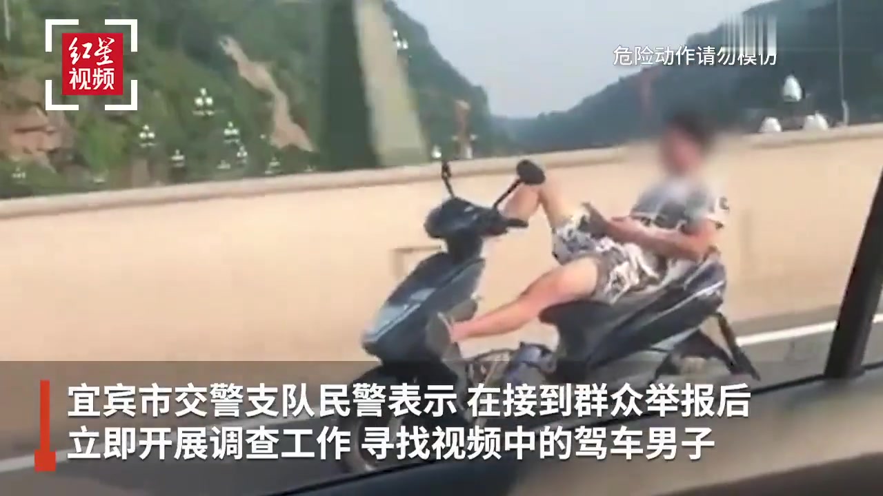 这是什么造型？男子躺着驾驶电瓶车，双手脱把玩手机游戏