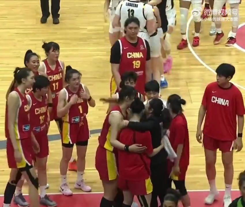 赛后原中国女篮教练郑薇与队员一一拥抱 远处比利时在庆祝