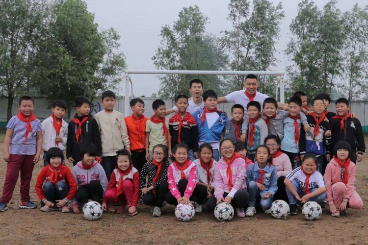 荆永兴与中国男足队员于大宝（后排右）一同参加“红粉笔”公益支教活动