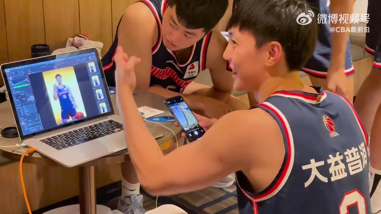 广东男篮全队拍摄官方写真，胡明轩蹲电脑前挨个验收队友的照片