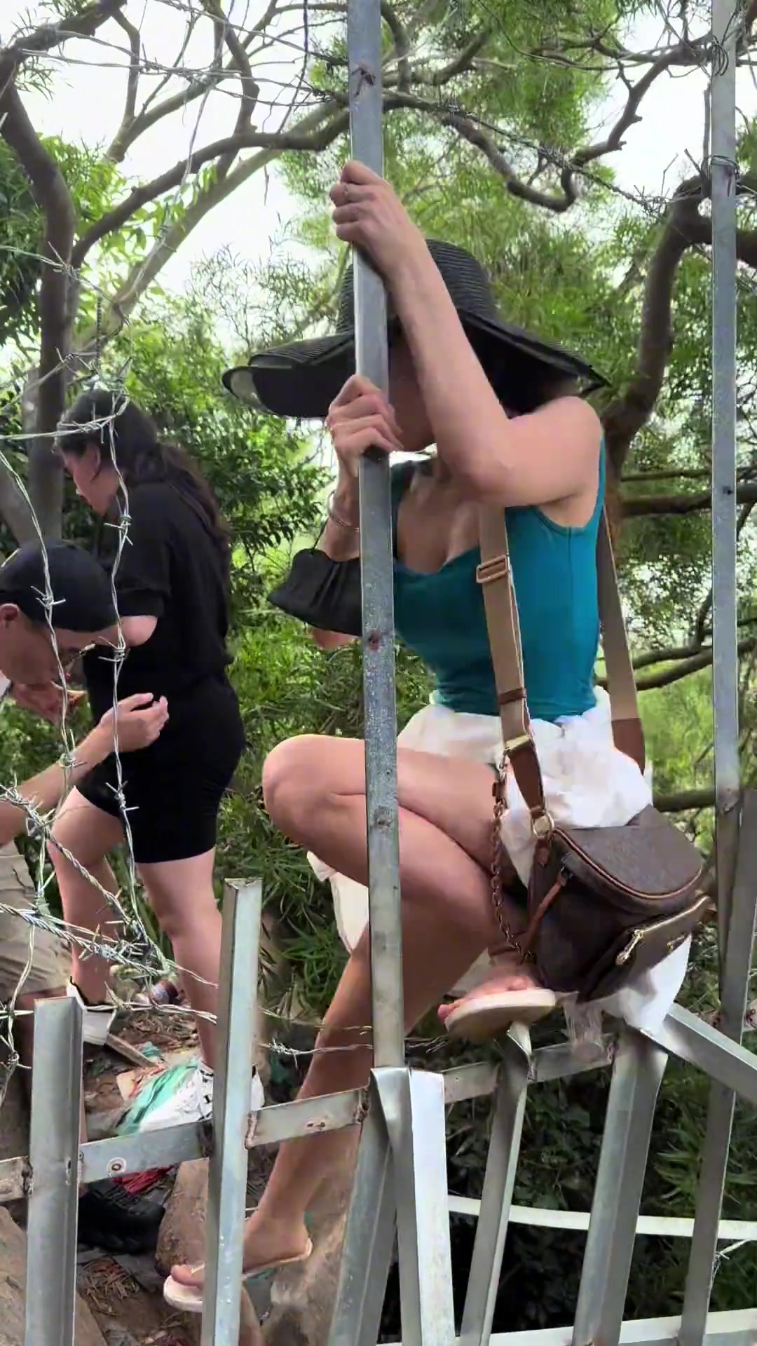 女生短袖短裤的也敢翻这种带刺的围栏啊