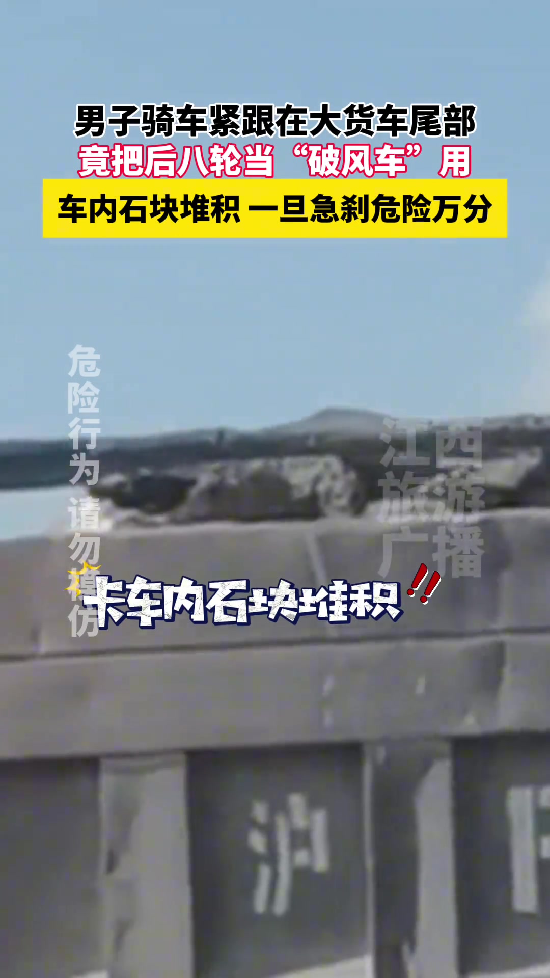 男子骑车紧跟在一辆装满石块的大货车尾部