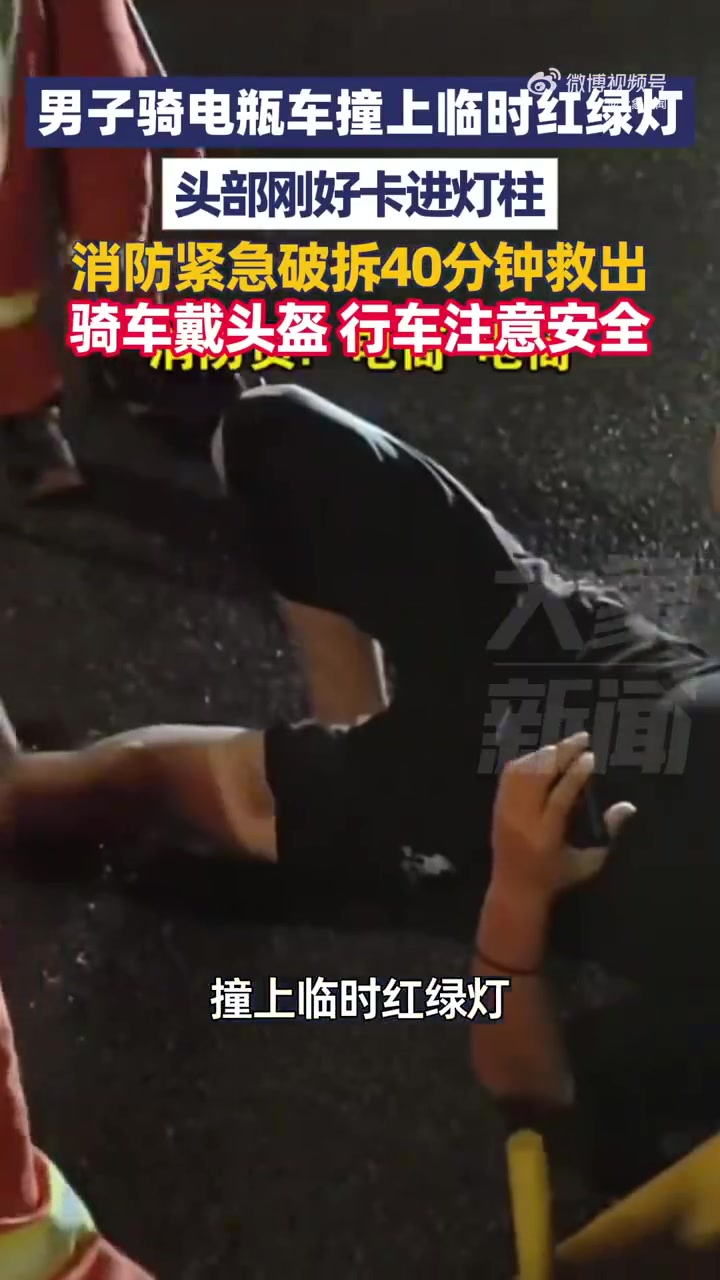 男子骑电动车撞马路中间临时红绿灯，头部卡灯箱