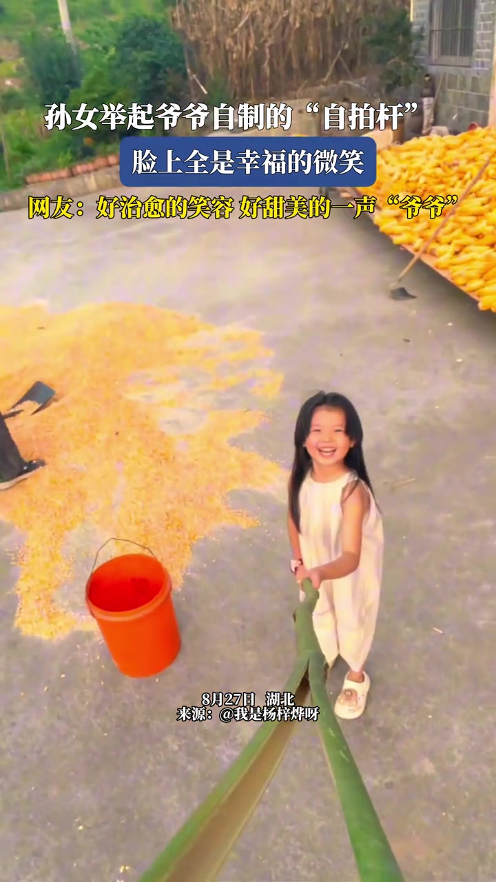 孙女举起爷爷自制的自拍杆，脸上全是幸福的微笑