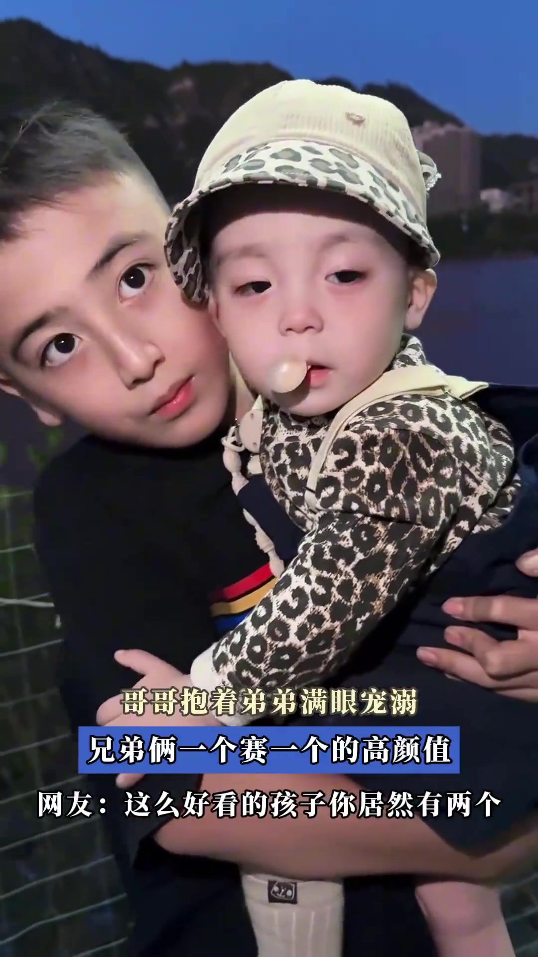 哥哥抱着弟弟满眼宠溺，兄弟俩一个比一个的高颜值
