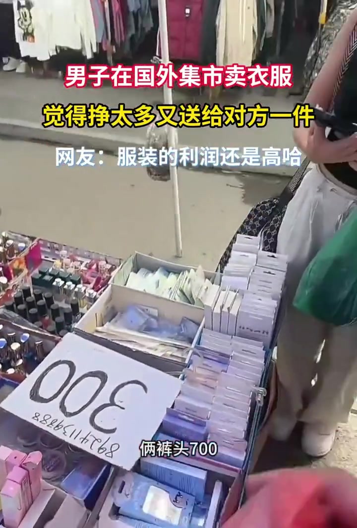男子在国外集市卖衣服，觉得挣太多，又送给对方一件！！