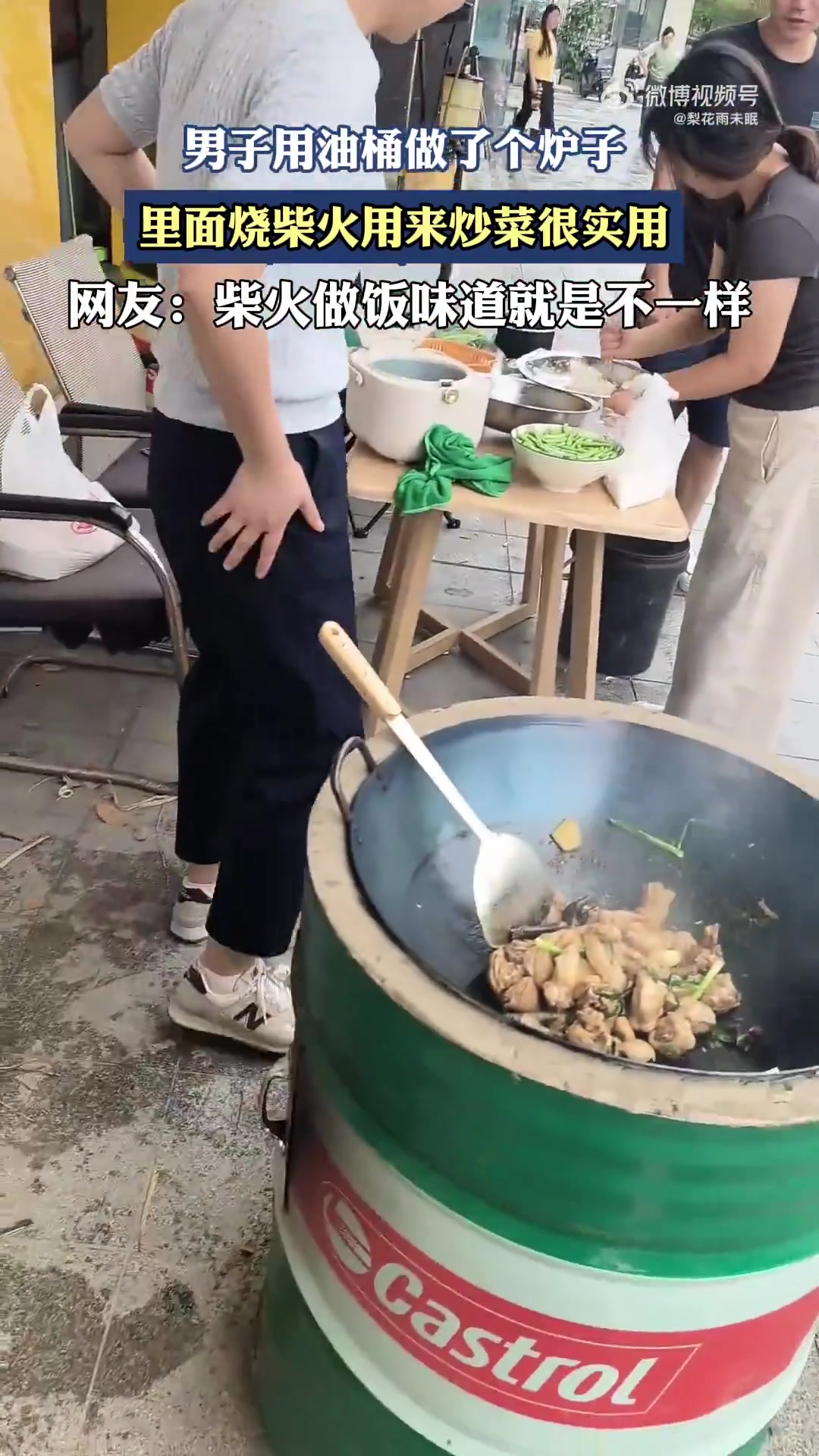 男子用油桶做了个炉子，里面烧柴火用来炒菜很实用
