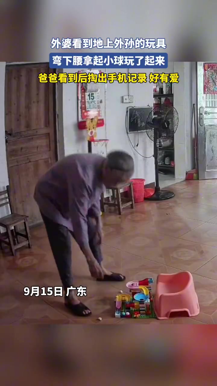 外婆看到地上外孫的玩具，彎下腰拿起小球玩了起來