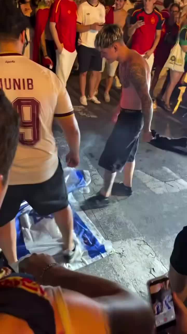 夺冠后的西班牙球迷在庆祝时,脚踩+车轧以色列国旗 夺冠后的西班牙球迷在庆祝时,脚踩+车轧以色列国旗